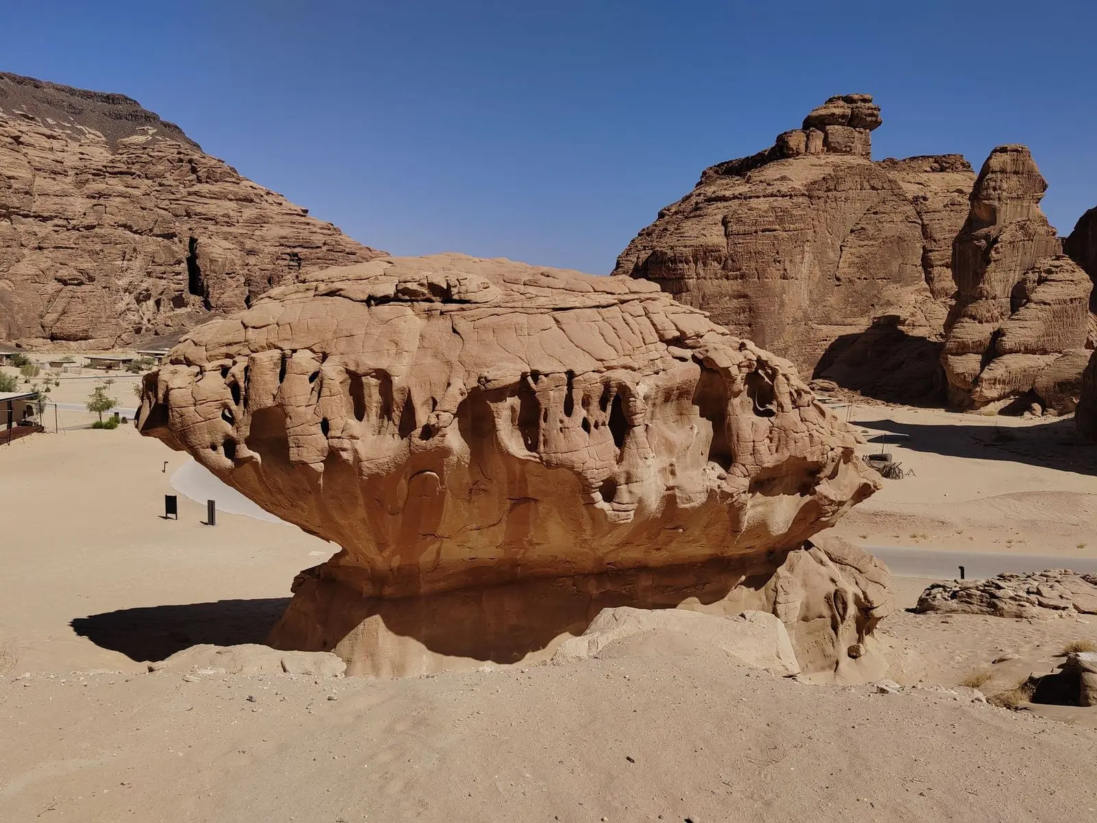 Layered sandstone hills under a blue sky in AlUla.