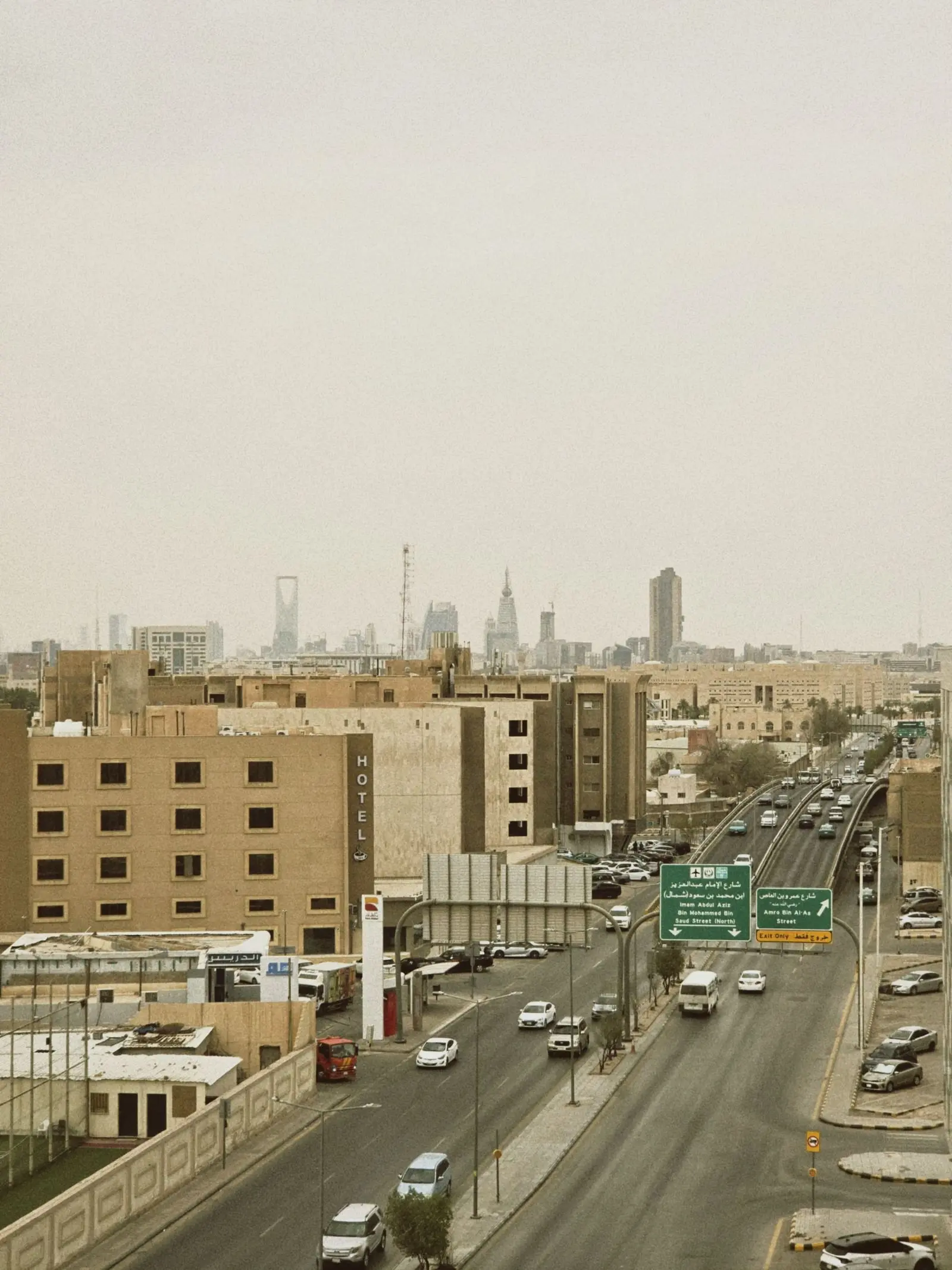 Aerial view of Riyadh streets with high-rise buildings in the distance.
