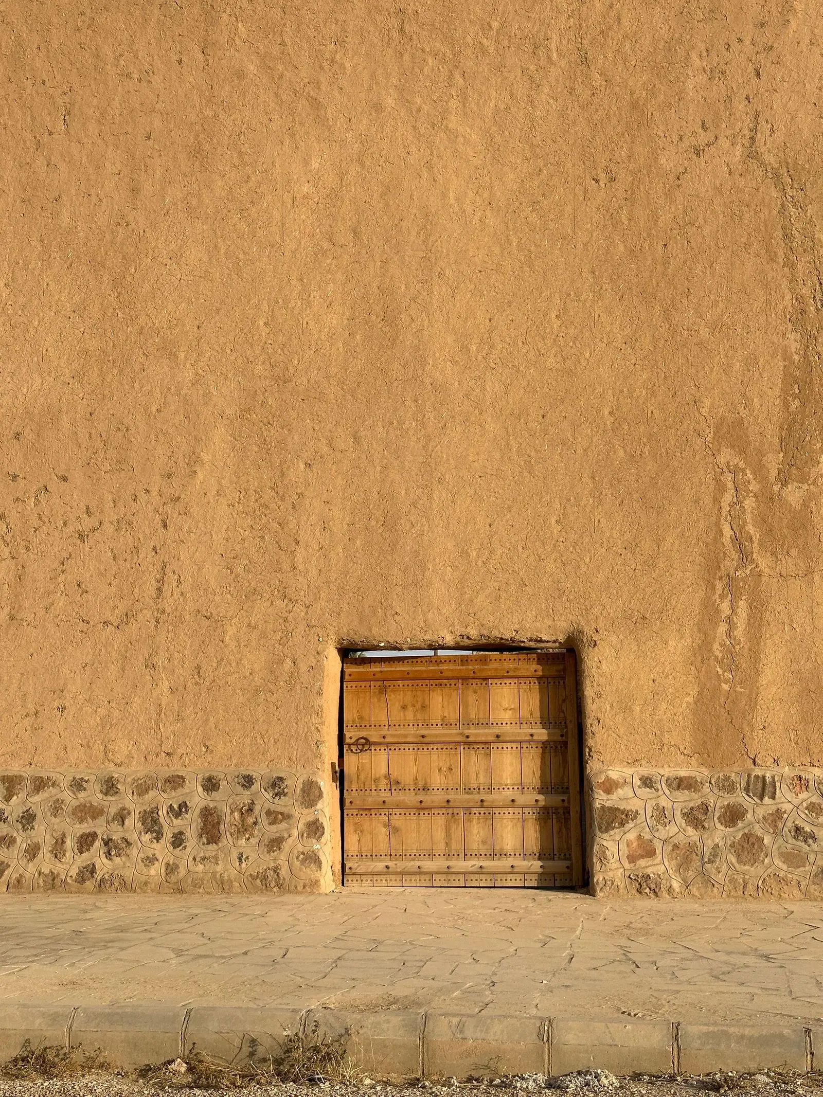 A low mud-brick house with small openings in Sadus, Riyadh Province.